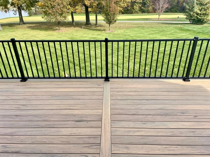 Wooden deck with black aluminum fencing.