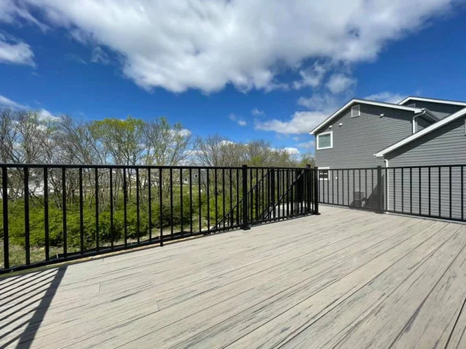Grey wooden deck with black aluminum fence.