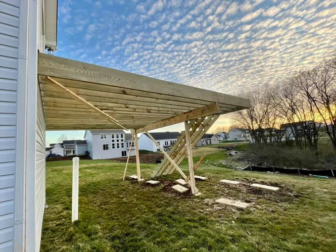 Wooden decking near house with white siding.