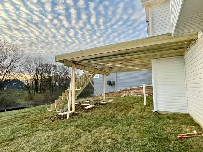 Wooden decking near house with white siding.