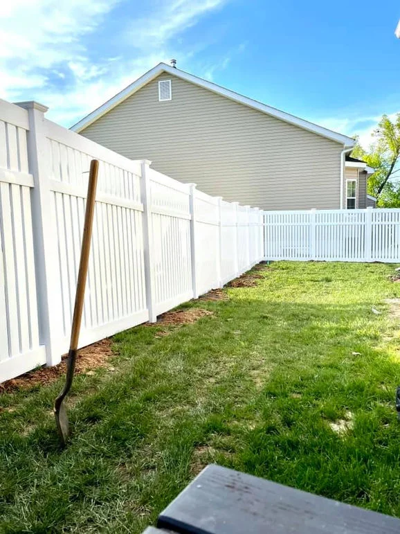 White vinyl fence with house in sight.
