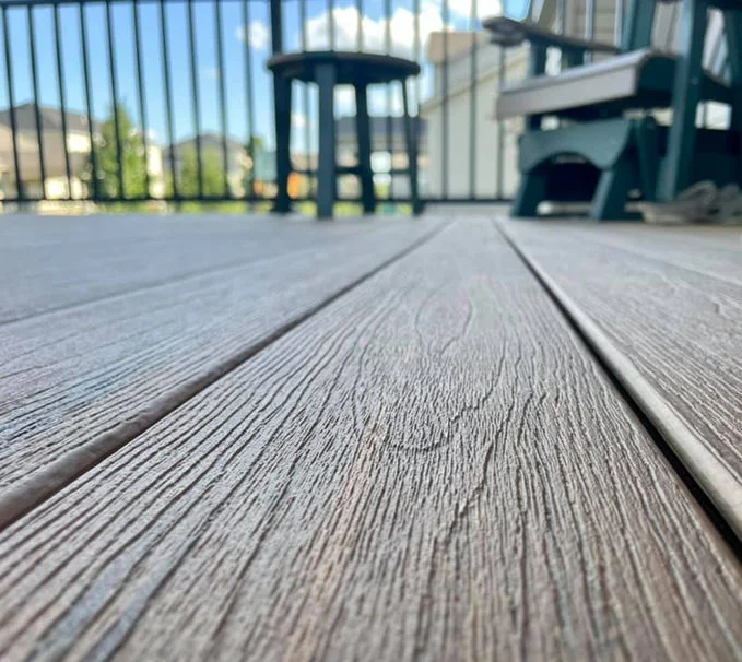 Wooden deck with aluminum fence and charis in sight.